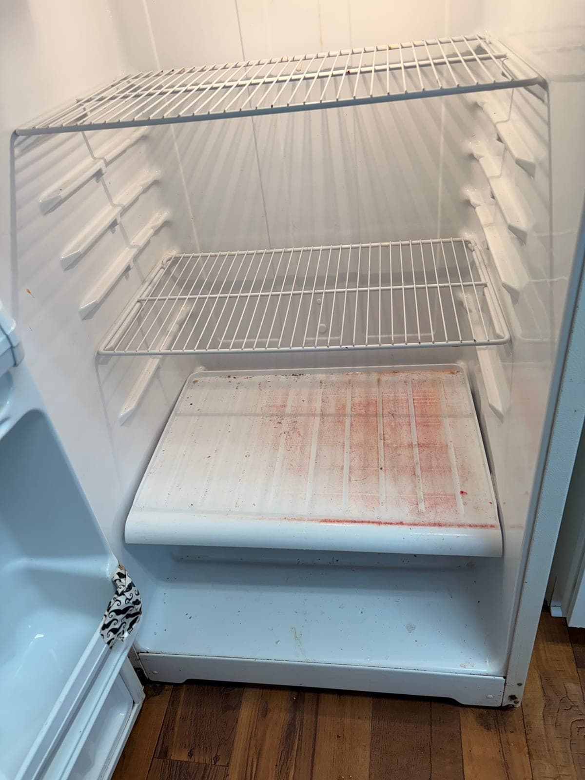 Refrigerator shelf before cleaning, with dried spill stains